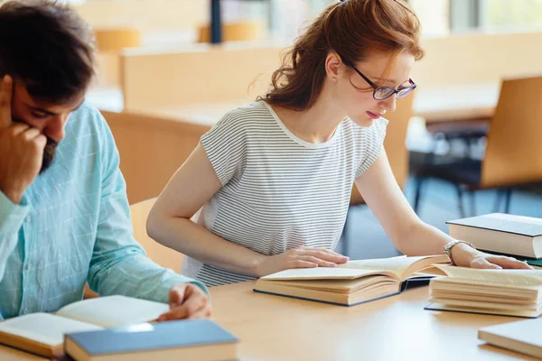 Joven estudiante estresada estudiando pila de libros — Foto de Stock