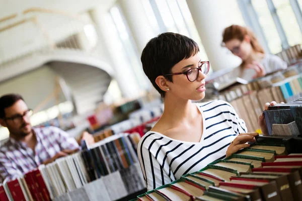 Frau liest ein Buch in der Bibliothek — Stockfoto