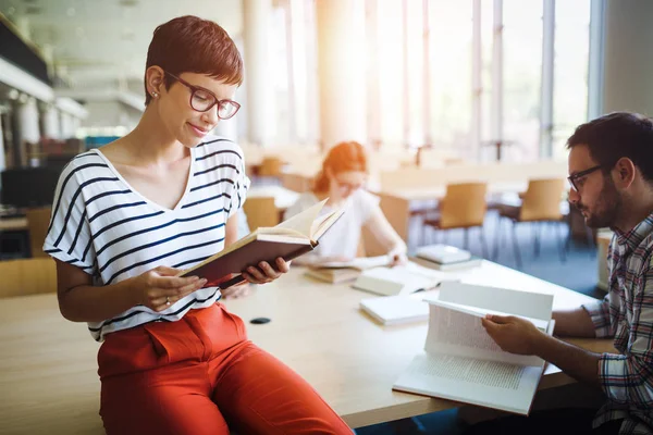 Mujer leyendo un libro en la biblioteca — Foto de Stock