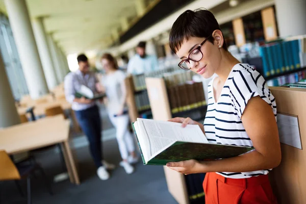 Mulher lendo um livro na biblioteca — Fotografia de Stock