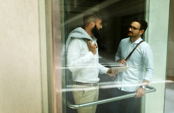 Фото молодых бизнесменов, разговаривающих в лифте — стоковое фото