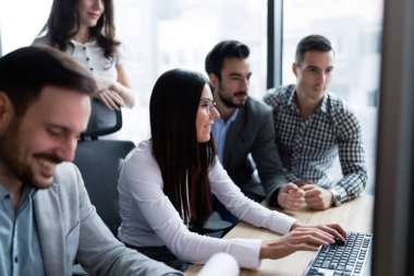 Modern ofis içinde bilgisayar üzerinde çalışan genç iş adamları
