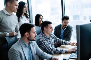 Modern ofis içinde bilgisayar üzerinde çalışan genç iş adamları