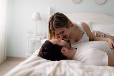 çekici çift yatakta romantik vakit geçiriyor