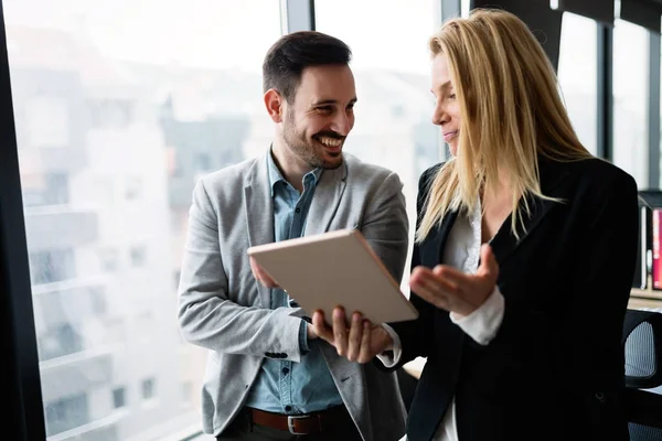 Aantrekkelijke business paar met behulp van de tablet in hun bedrijf — Stockfoto