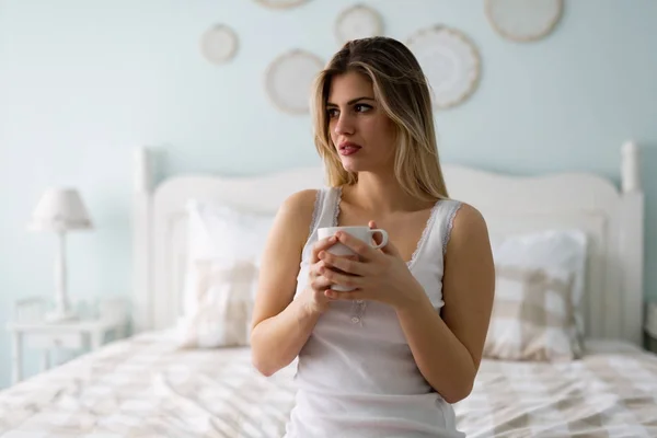 Frau sitzt zu Hause auf Bett — Stockfoto