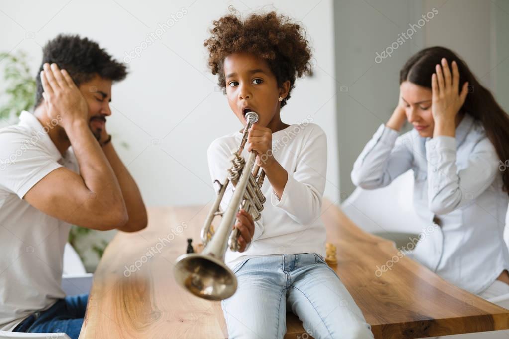 child making noise by playing trumpet