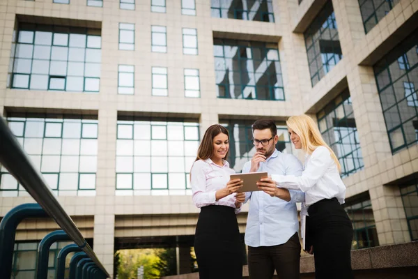 Imagen de socios empresariales jóvenes y atractivos de pie — Foto de Stock