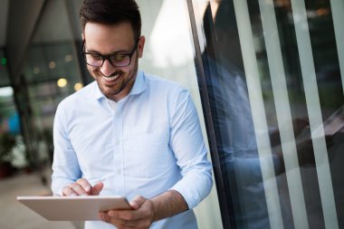 Tablet tutan bardaklarda işadamı portresi