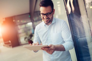 Tablet tutan bardaklarda işadamı portresi