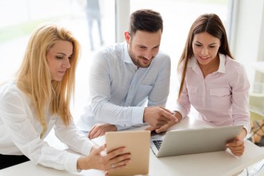 Ofiste bilgisayar üzerinde çalışan genç iş adamları