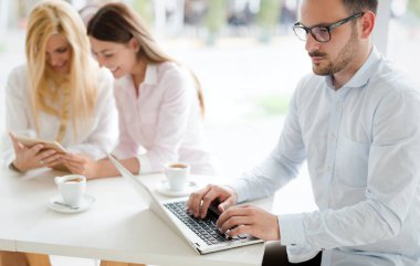 Birlikte laptop çalışma arkadaşları gülümseyerek üç genç