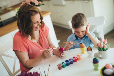 Anne ve oğlu Paskalya yumurtaları boya