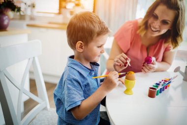 Anne ve oğlu eğlenceli olan yumurta süslemek