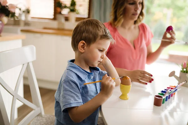 Mother and her son having fun decorate eggs — Stock Photo, Image