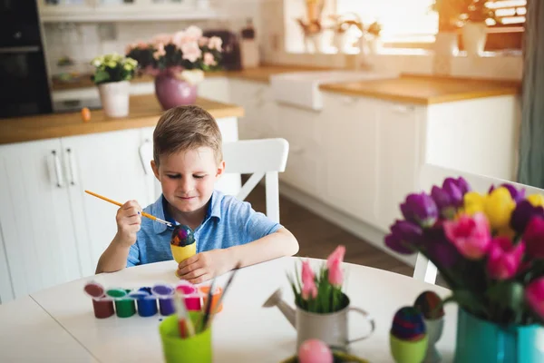 Kis gyerek fiú színezés tojás húsvéti ünnep a hazai konyha — Stock Fotó
