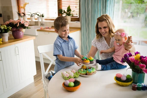 Mãe e crianças pintando ovos coloridos — Fotografia de Stock