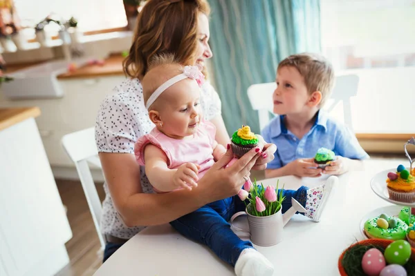 Діти з матір'ю їдять кекси — стокове фото