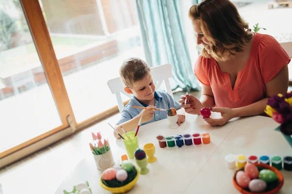 Jonge moeder en haar zoon plezier terwijl schilderij eieren voor Pasen — Stockfoto