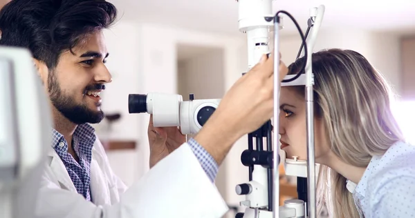 Оптометрист, проверяющий зрение и коррекцию зрения пациента — стоковое фото