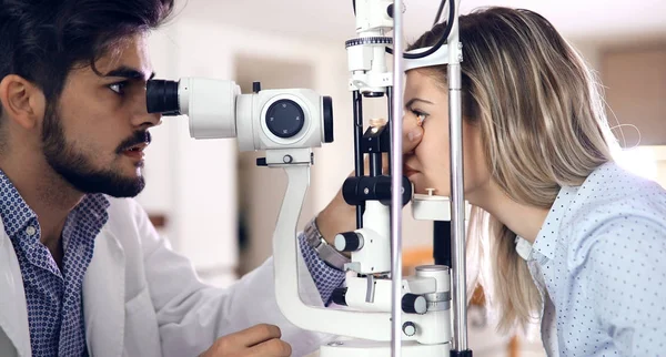 De examencommissie patiënt optometrist in moderne oogheelkunde kliniek — Stockfoto