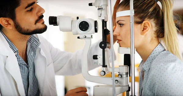 Оптометрист вивчає пацієнта в сучасній офтальмологічній клініці — стокове фото