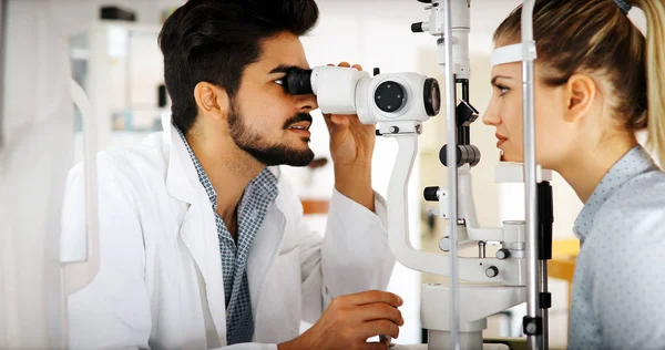 Optometrista attento esaminando paziente femminile su lampada a fessura — Foto Stock