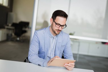 Genç yakışıklı mimar ofis içinde laptop üzerinde çalışıyor