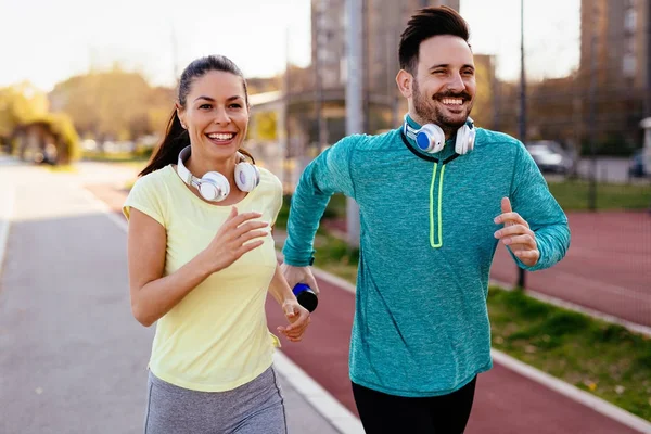 Young attractive couple running outside on sunny day — Stock Photo, Image