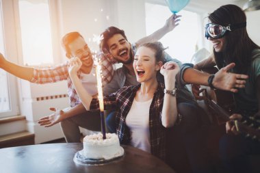 Bir grup mutlu arkadaş doğum gününü kutluyor.