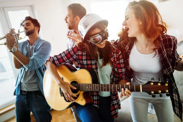 Junge fröhliche tanzende Mädchen, die Gitarre spielen und feiern — Stockfoto
