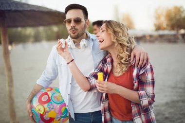 Gülen ve having fun mutlu çifti kumsalda zaman