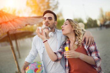 Gülen ve having fun mutlu çifti kumsalda zaman