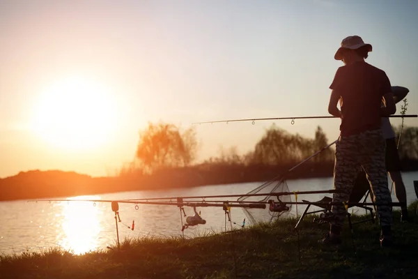 Gün batımı balıkçılık ve hobi tadını çıkarırken rahatlatıcı erkekler — Stok fotoğraf