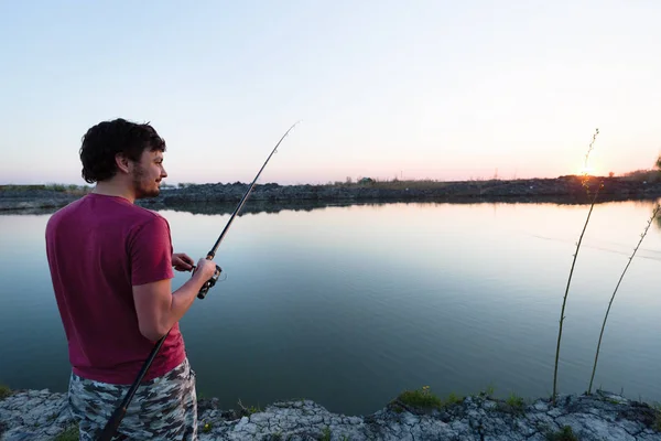 Junger Mann angelt am Teich und genießt Hobby — Stockfoto