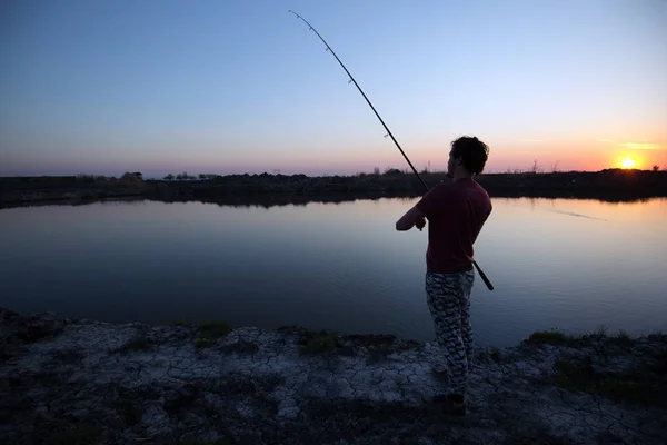 Los hombres que pescan en la puesta del sol y relajarse mientras disfruta de hobby — Foto de Stock