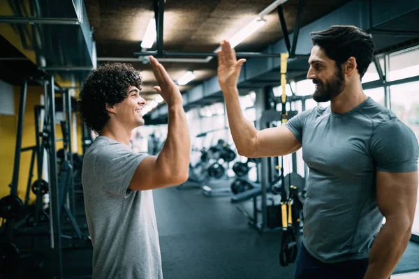 Young man doing workout with a personal trainer.