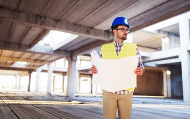 Mühendis bir mavi parmak tutan bir şantiyeye çalışıyor