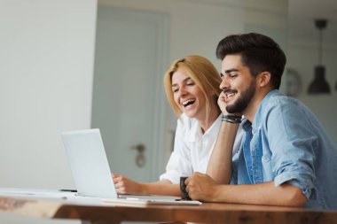 Yakışıklı genç ve çekici kadın birlikte dizüstü bilgisayarda çalışan