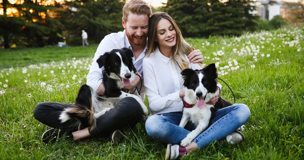 Beautiful couple walking dogs — Stock Photo, Image