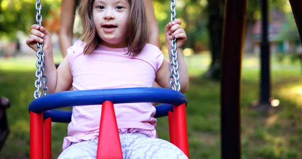 Ritratto Bella Bambina Con Sindrome Che Oscilla Nel Parco Giochi — Foto Stock