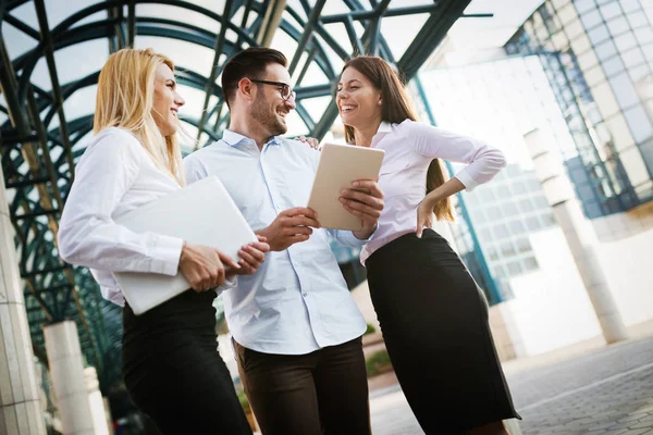 Picture of young attractive business partners standing outdoor