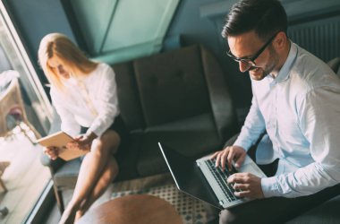 Modern ofis içinde bilgisayar üzerinde çalışan genç iş adamları