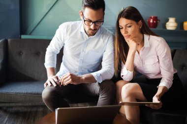 Modern ofis içinde bilgisayar üzerinde çalışan genç iş adamları