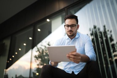 Tablet açık havada tutan bardaklarda işadamı portresi