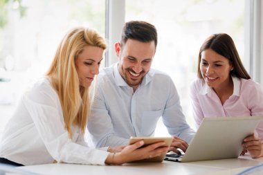 İş arkadaşları laptop bakarken gülüyor