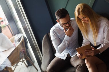 Modern ofis içinde bilgisayar üzerinde çalışan genç iş adamları