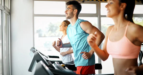 Amigos haciendo ejercicio en la máquina de cinta de correr — Foto de Stock