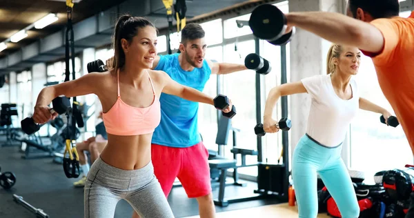 Group of friends exercising together in gym