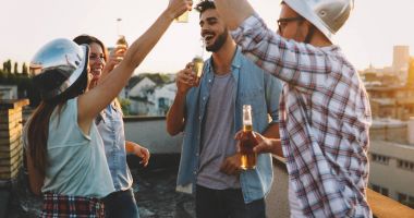 Bir grup mutlu genç arkadaş çatıda parti veriyor.